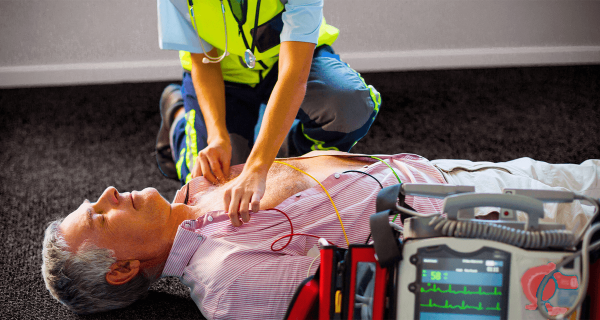 Man lying on the floor with EMS providing CPR with a defibrillator